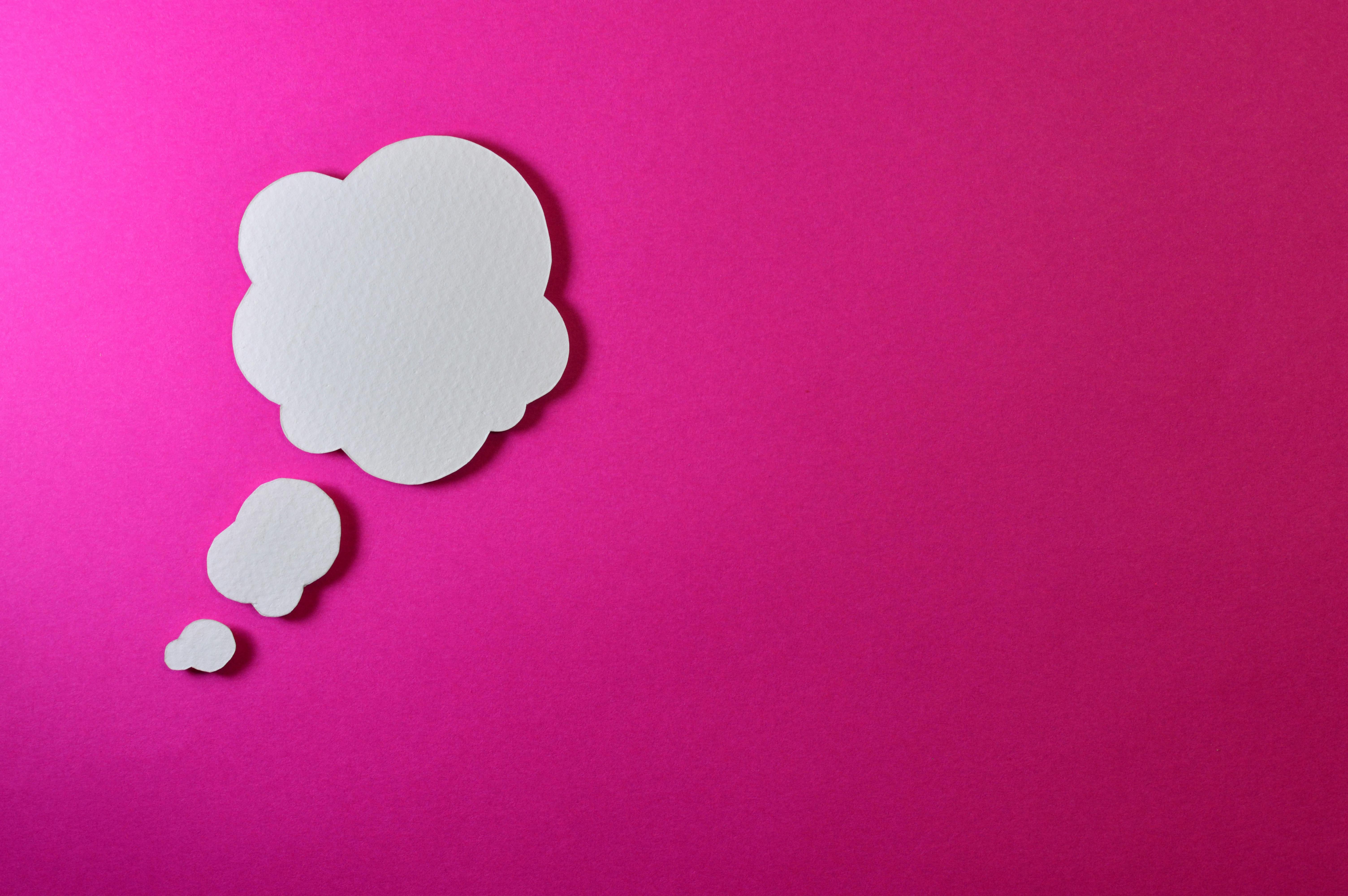 A thinking bubble on a pink background